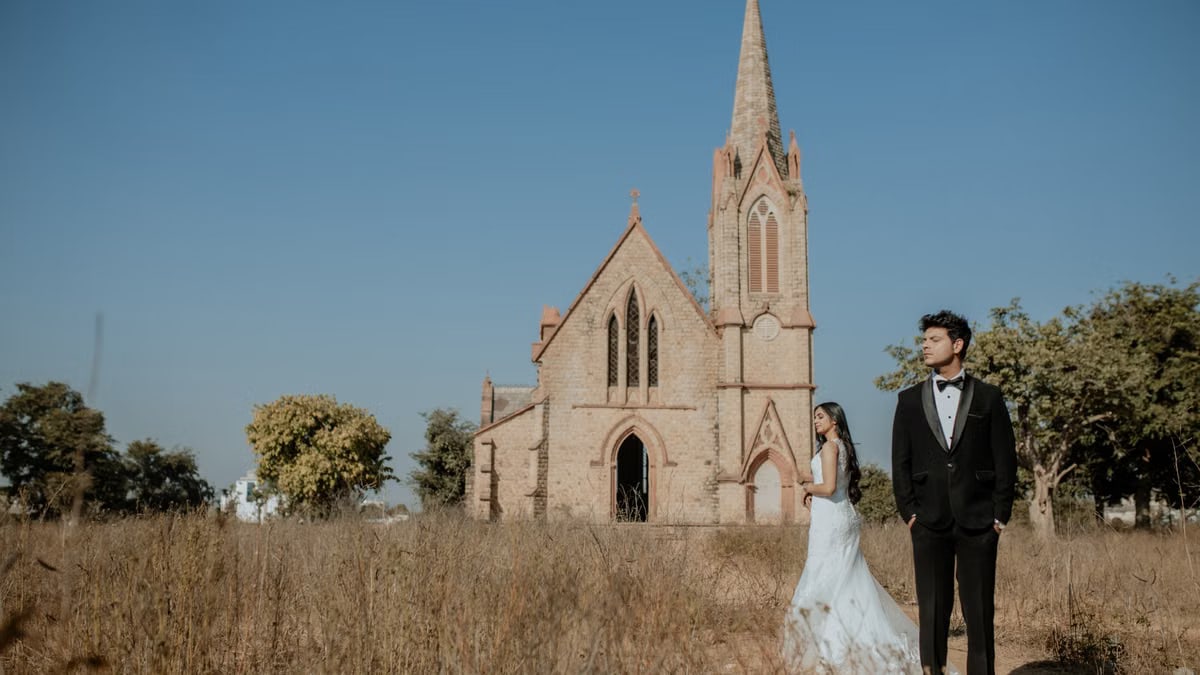 Elegant couple in front of a historic church during a pre-wedding photoshoot.